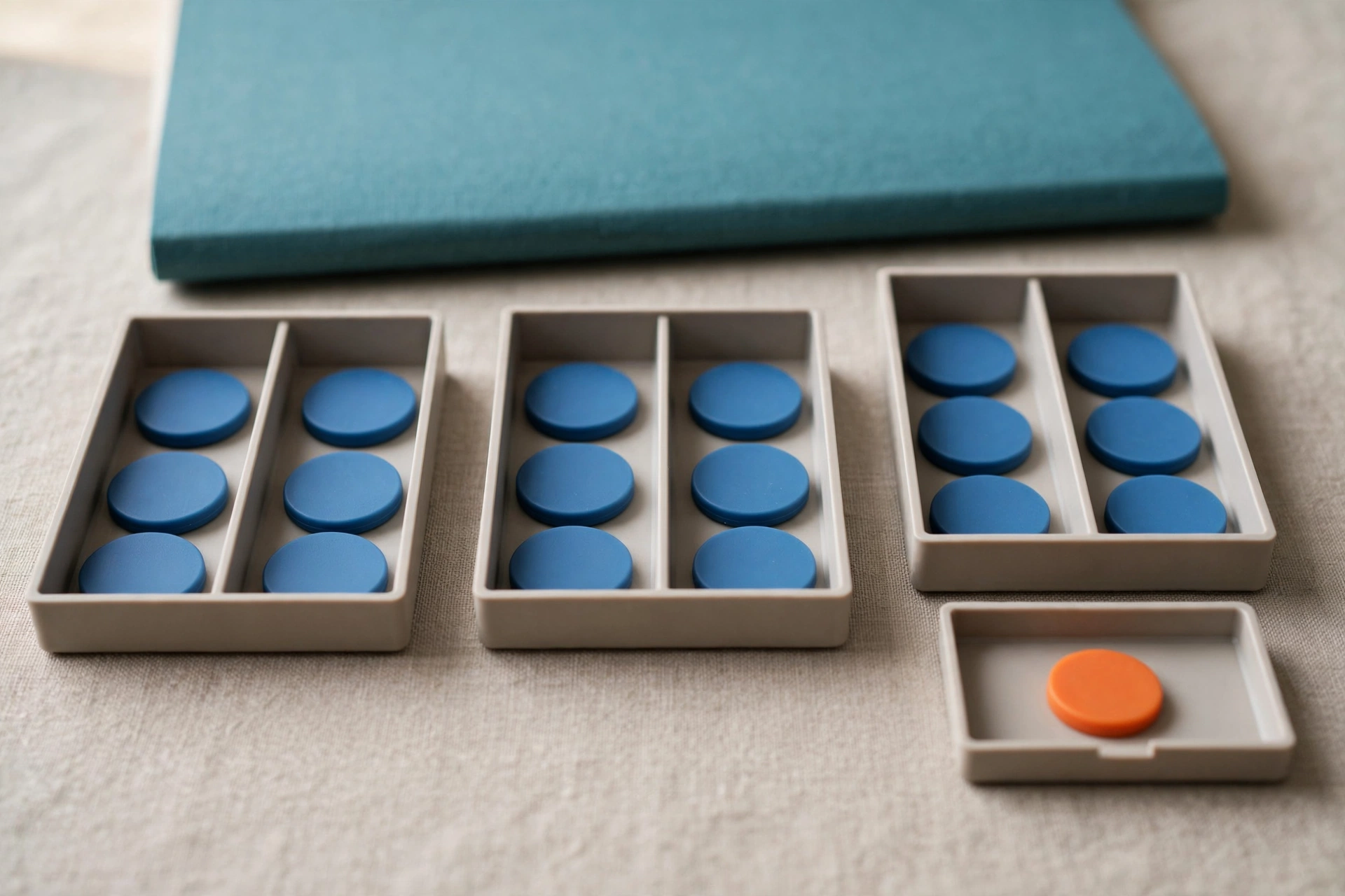 Blue tokens are distributed in trays, with one orange token in a separate tray, representing resource allocation.