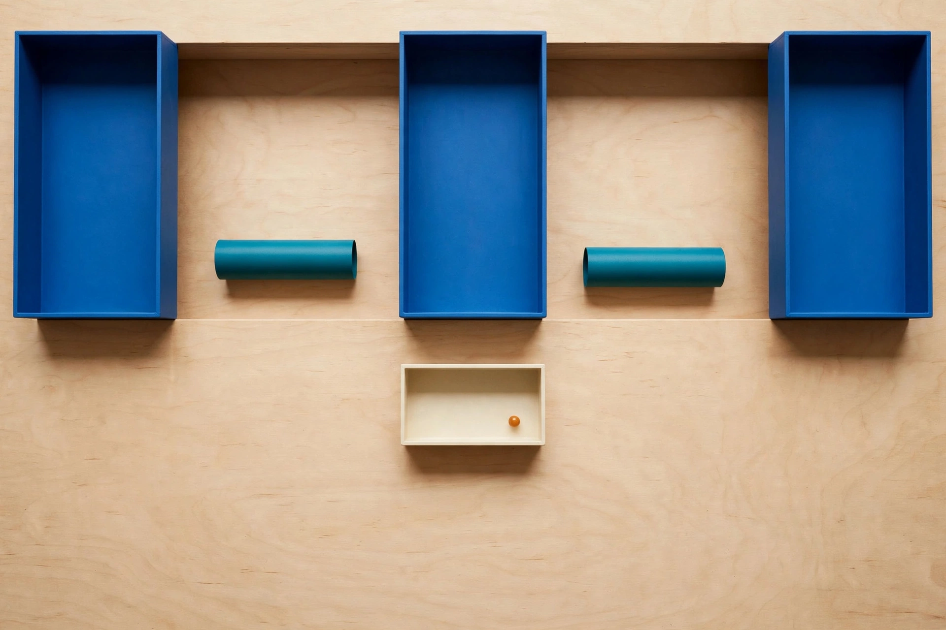 Three blue rectangular trays are arranged in a row above a single ivory tray containing an orange bead, with teal cylinders placed between the upper trays.