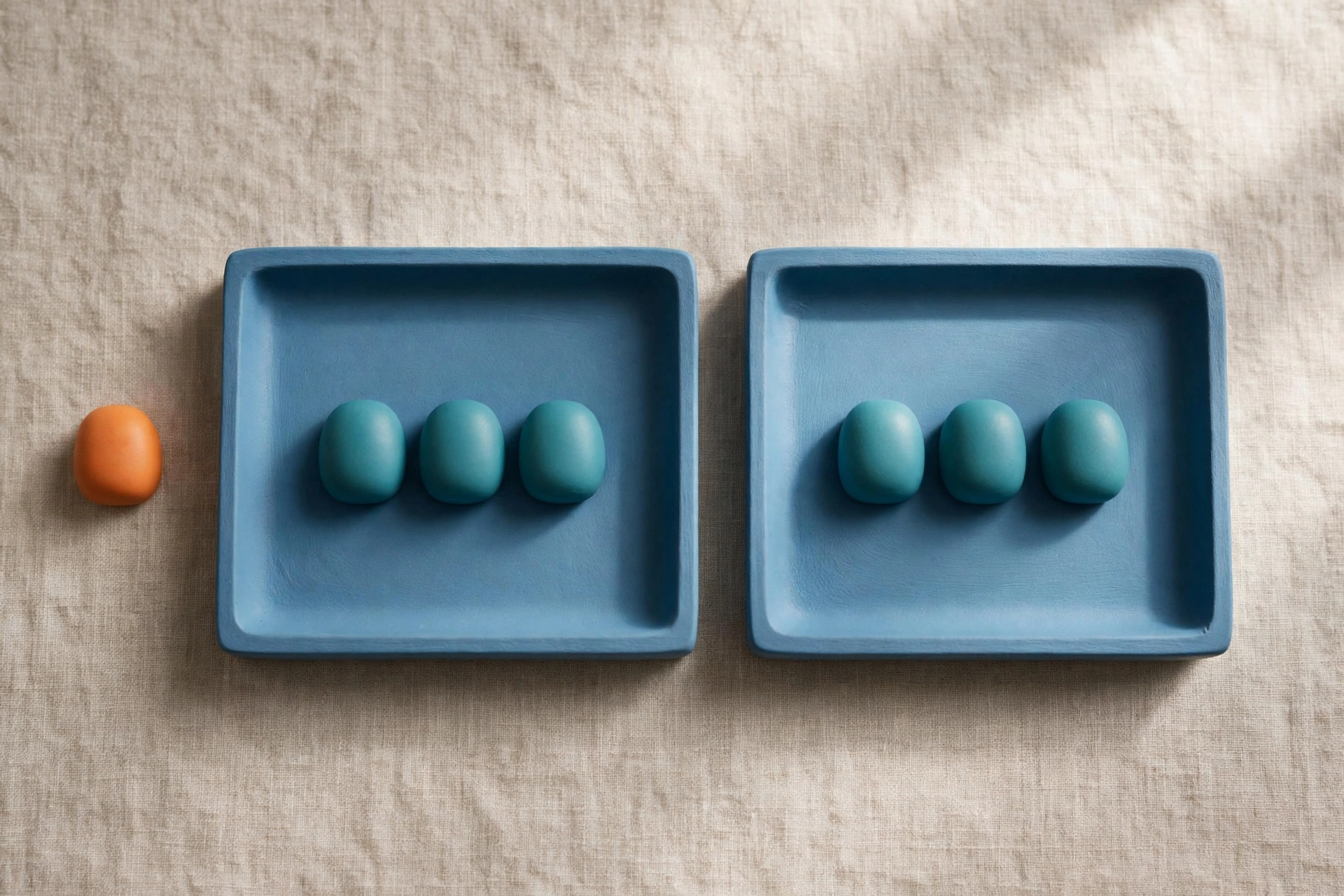 Two blue trays hold teal tokens, with an orange token placed separately to represent billing plan comparison.