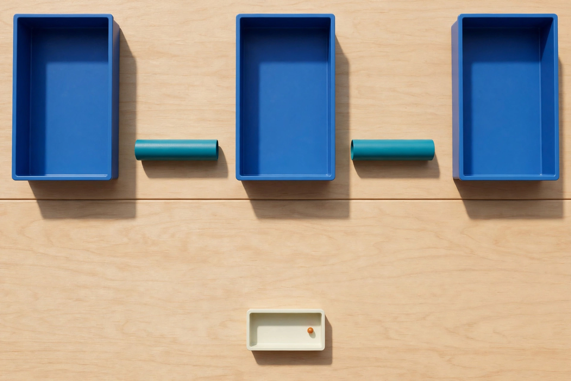 Three blue rectangular trays are arranged in a row on a wooden surface, with teal cylinders in the gaps between them.